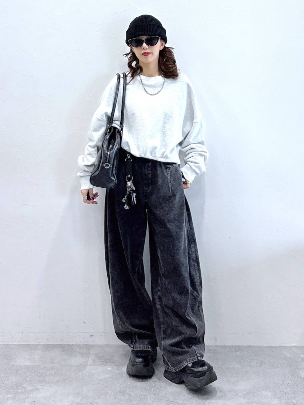 ブラック系のブーツ、ブラック系のボストンバッグ、ブラック系のデニムパンツを着用したレディースの冬コーディネートの1枚目の写真