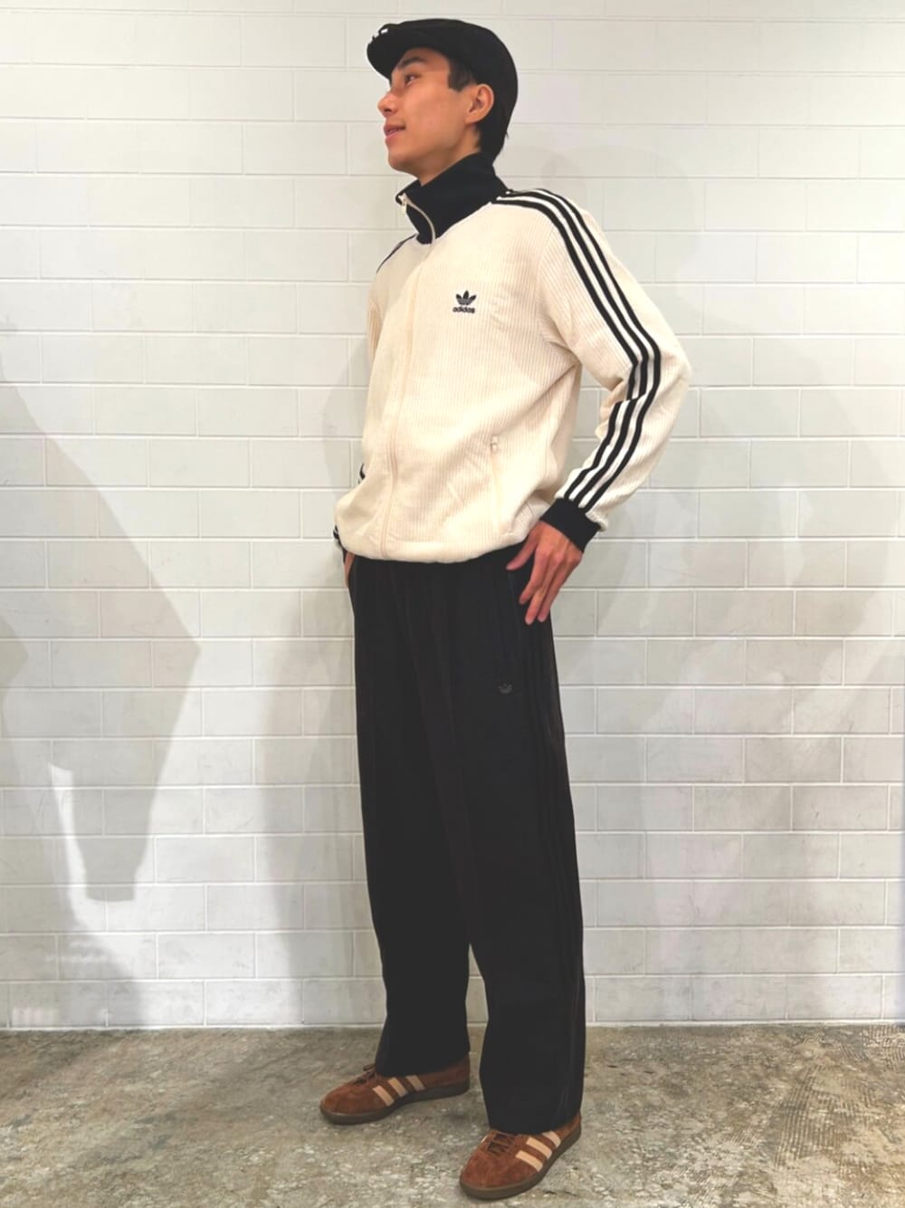 ホワイト系のジャージ、ブラック系のスウェットパンツ、ブラウン系のスニーカーを着用したメンズの秋コーディネートの1枚目の写真