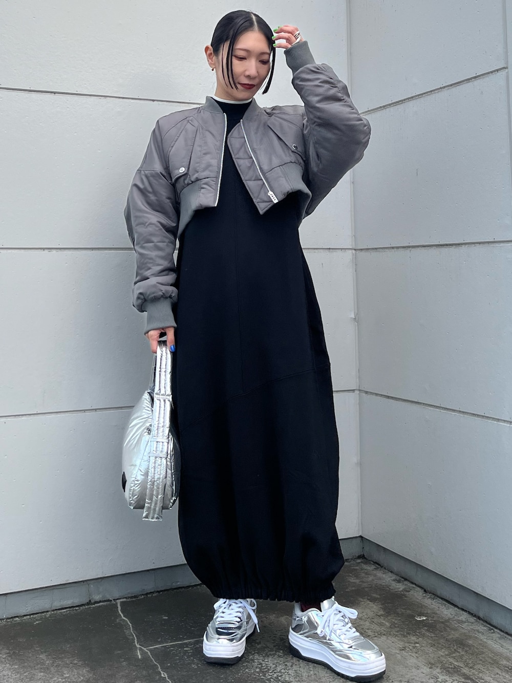 ブラック系のワンピース、グレー系のMA-1、シルバー系のハンドバッグを着用したレディースの冬コーディネートの1枚目の写真