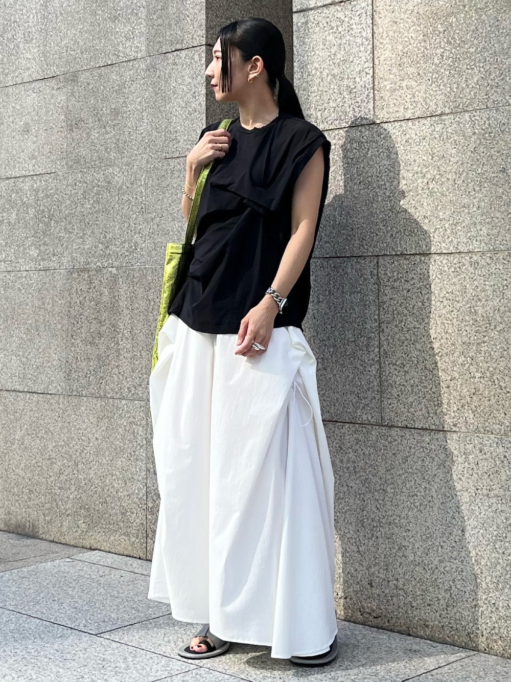 イエロー系のトートバッグ、ブラック系のTシャツ/カットソー、ホワイト系のその他パンツを着用したレディースの春コーディネートの1枚目の写真