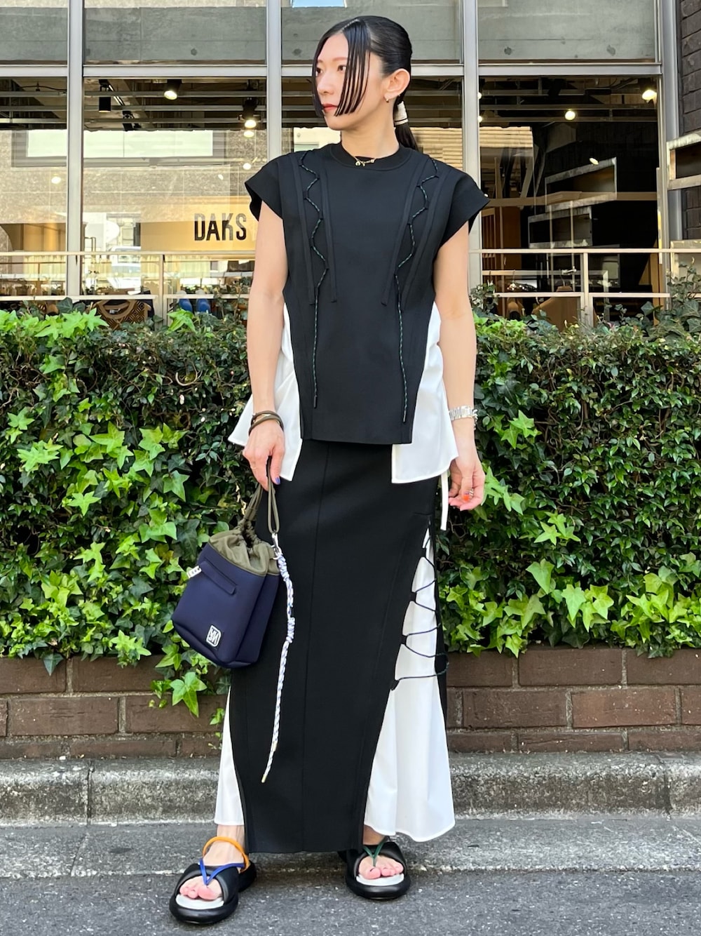 ブラック系のニット/セーター、ブラック系のスカート、その他のサンダルを着用したレディースの春コーディネートの1枚目の写真