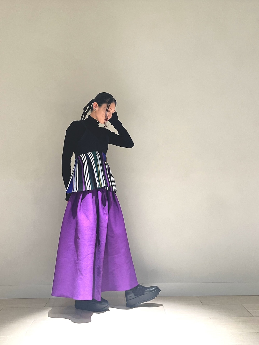 ブラック系のキャミソール、パープル系のスカート、ブラック系のブーツを着用したレディースの冬コーディネートの1枚目の写真