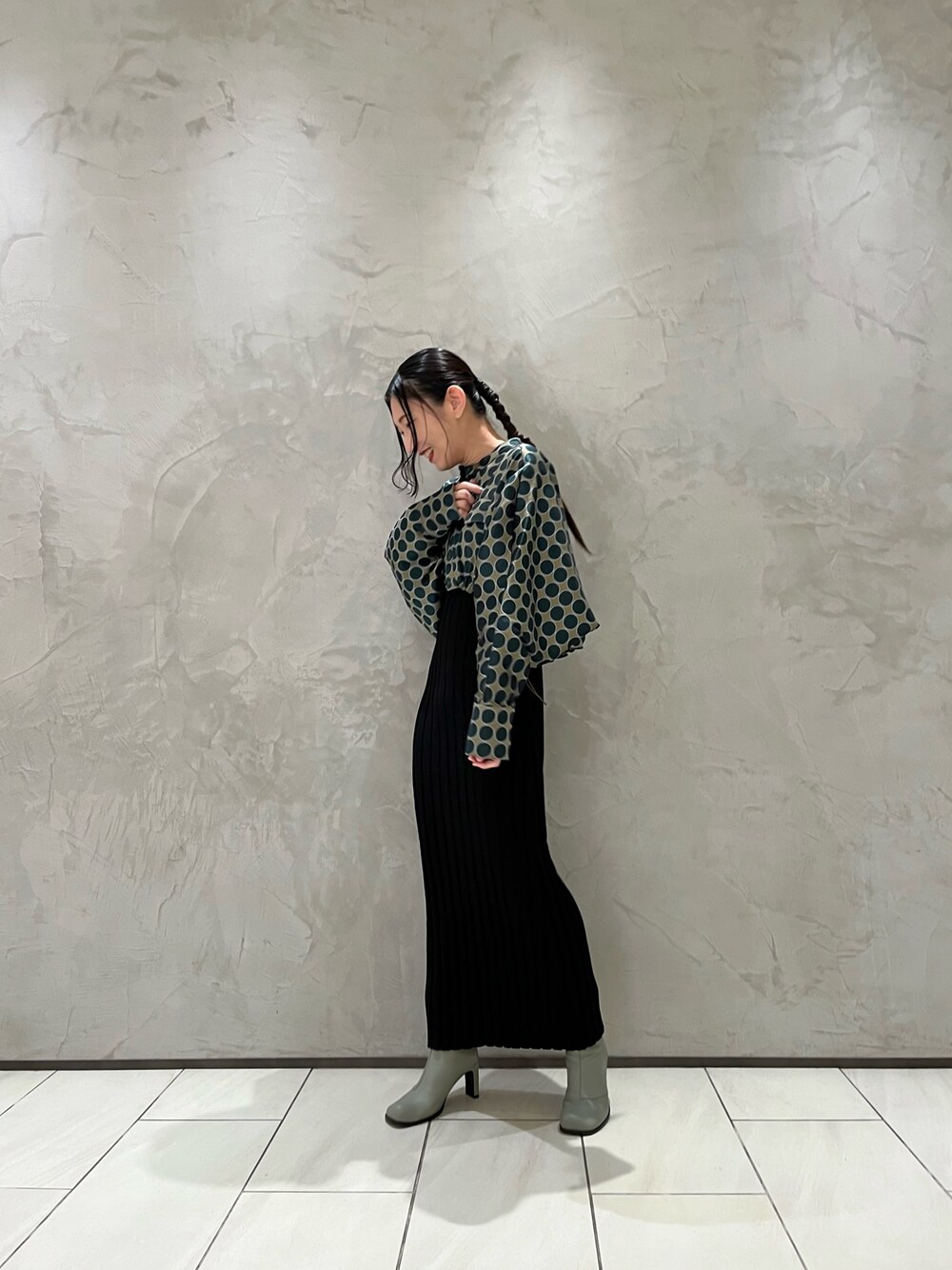 グリーン系のブルゾン、ブラック系のワンピース、ベージュ系のブーツを着用したレディースの冬コーディネートの1枚目の写真