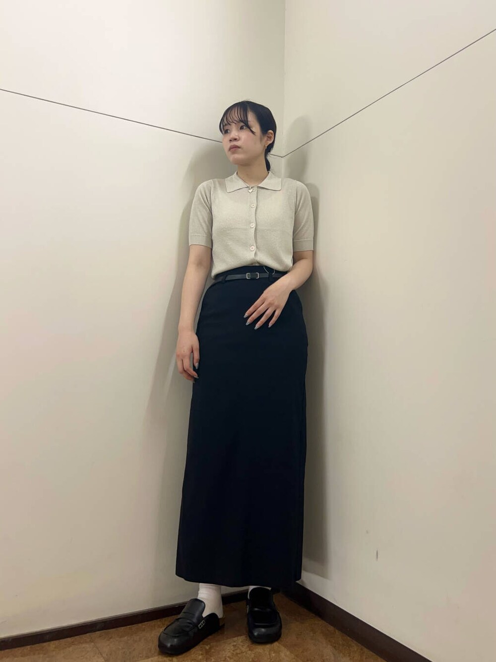 ブラック系のスカート、ホワイト系のニット/セーターを着用したレディースの夏コーディネートの1枚目の写真