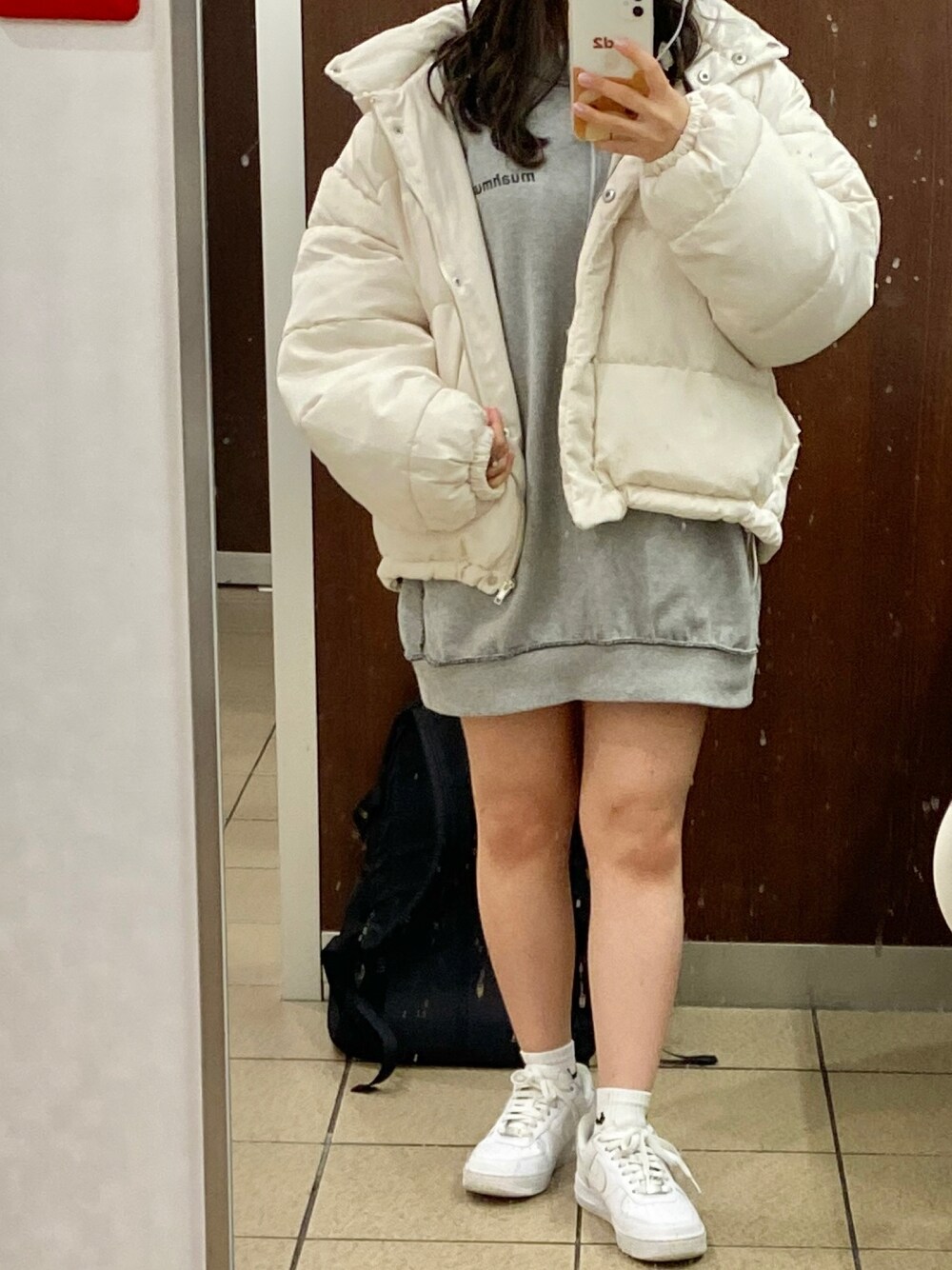 ホワイト系のダウンジャケット/コート、グレー系のスウェット、ホワイト系のスニーカーを着用したレディースの秋コーディネートの1枚目の写真