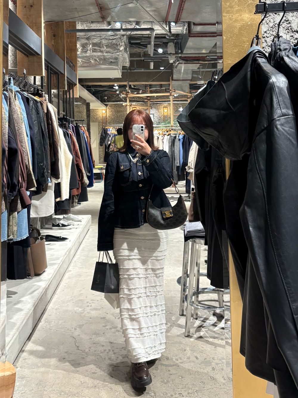 ブルー系のデニムジャケット、ホワイト系のスカート、ブラウン系のドレスシューズを着用したレディースの秋コーディネートの1枚目の写真