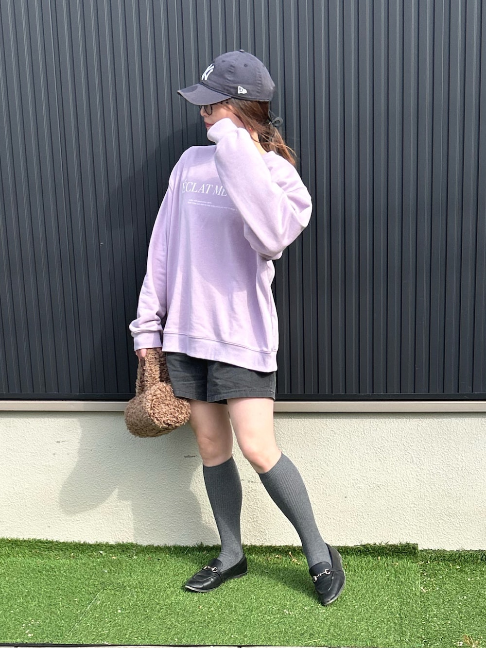 パープル系のスウェット、ブラウン系のショルダーバッグ、ブラック系のその他パンツを着用したレディースの冬コーディネートの1枚目の写真