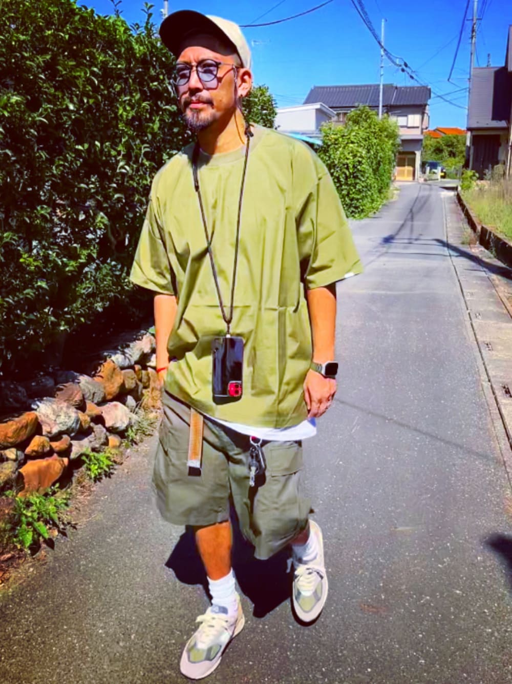 グリーン系のTシャツ/カットソー、グリーン系のその他パンツ、グレー系のスニーカーを着用したメンズの秋コーディネートの1枚目の写真