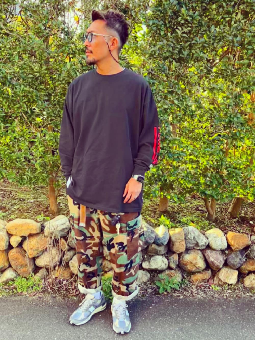 ブラック系のTシャツ/カットソー、その他のカーゴパンツ、グレー系のスニーカーを着用したメンズの秋コーディネートの1枚目の写真