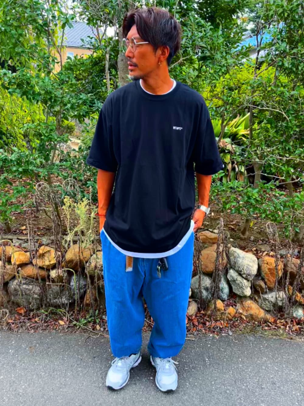 ブラック系のTシャツ/カットソー、ブルー系のデニムパンツ、グレー系のスニーカーを着用したメンズの秋コーディネートの1枚目の写真