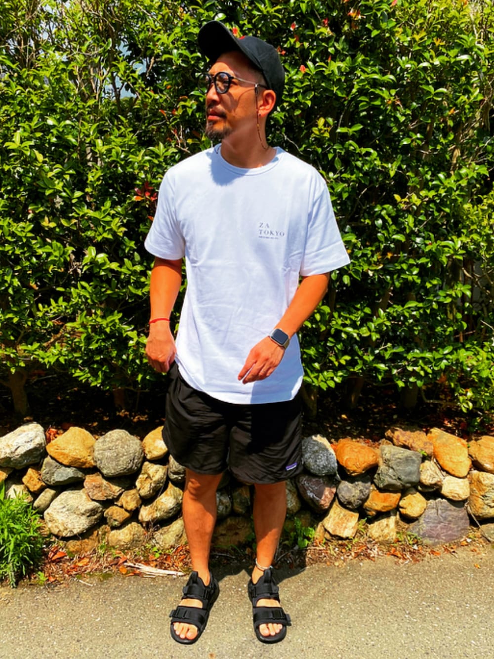 ホワイト系のTシャツ/カットソー、ブラック系のその他パンツ、ブラック系のサンダルを着用したメンズの夏コーディネートの1枚目の写真