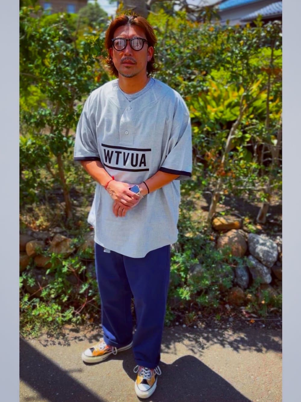 ブラック系のチノパンツ、グレー系のTシャツ/カットソー、その他のスニーカーを着用したメンズの春コーディネートの1枚目の写真
