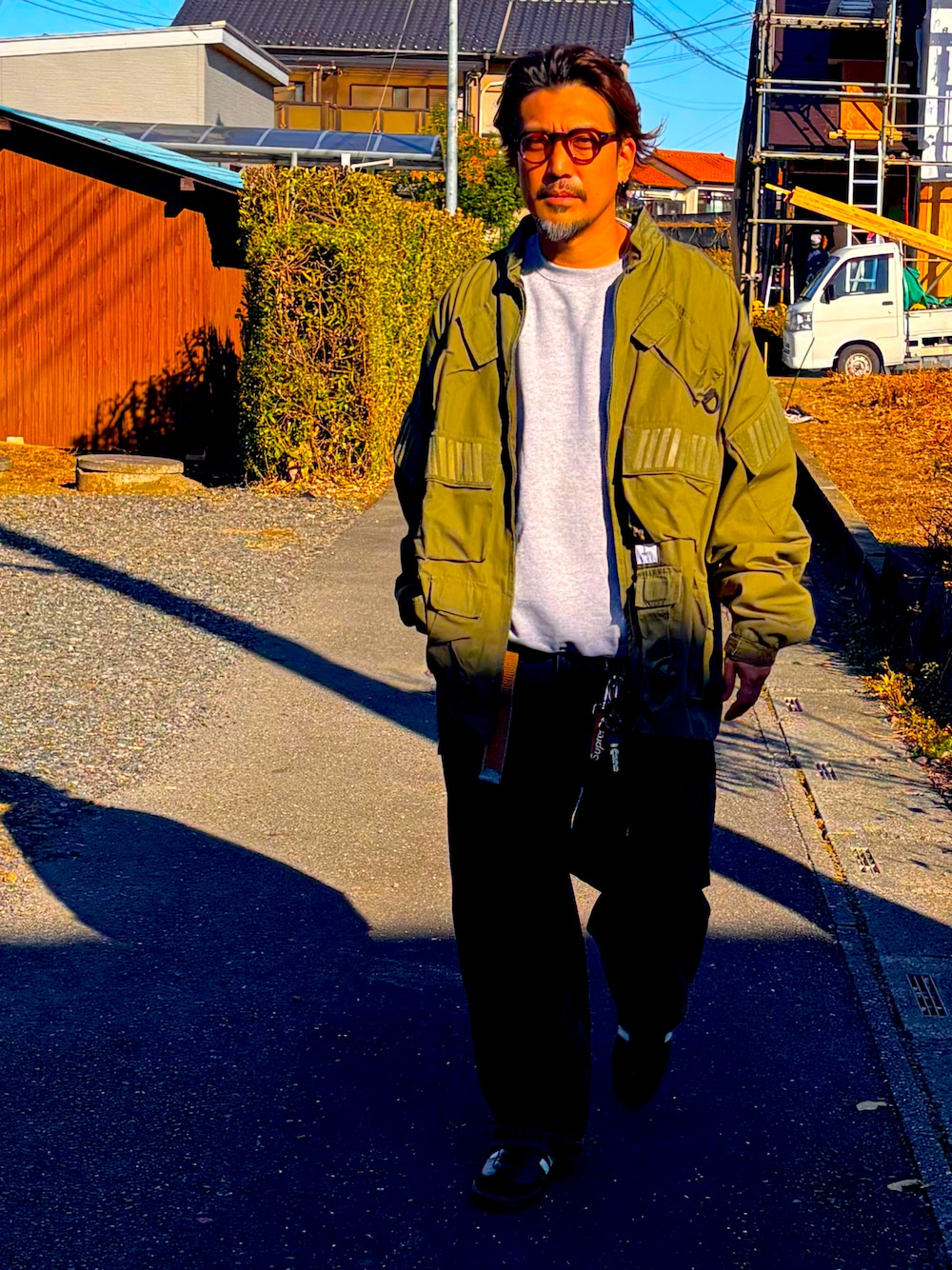 ブラック系のスニーカー、グレー系のスウェット、ブラック系のデニムパンツを着用したメンズの冬コーディネートの1枚目の写真