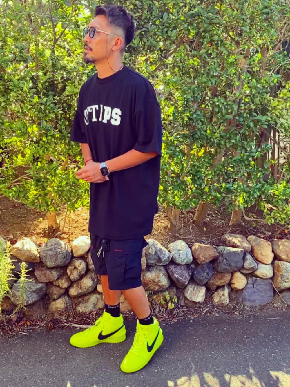 ブラック系のTシャツ/カットソー、ブラック系のカーゴパンツ、イエロー系のスニーカーを着用したメンズの夏コーディネートの1枚目の写真