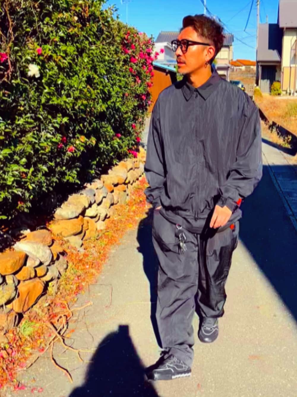 ブラック系のナイロンジャケット、ブラック系のその他パンツ、ブラック系のスニーカーを着用したメンズの冬コーディネートの1枚目の写真