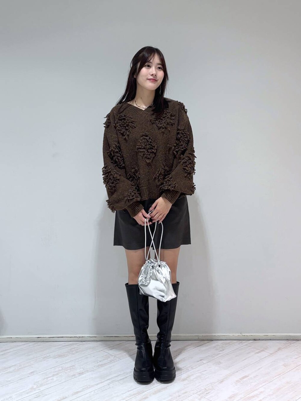 ブラック系のブーツ、グレー系のその他パンツ、ブラウン系のニット/セーターを着用したレディースの冬コーディネートの1枚目の写真