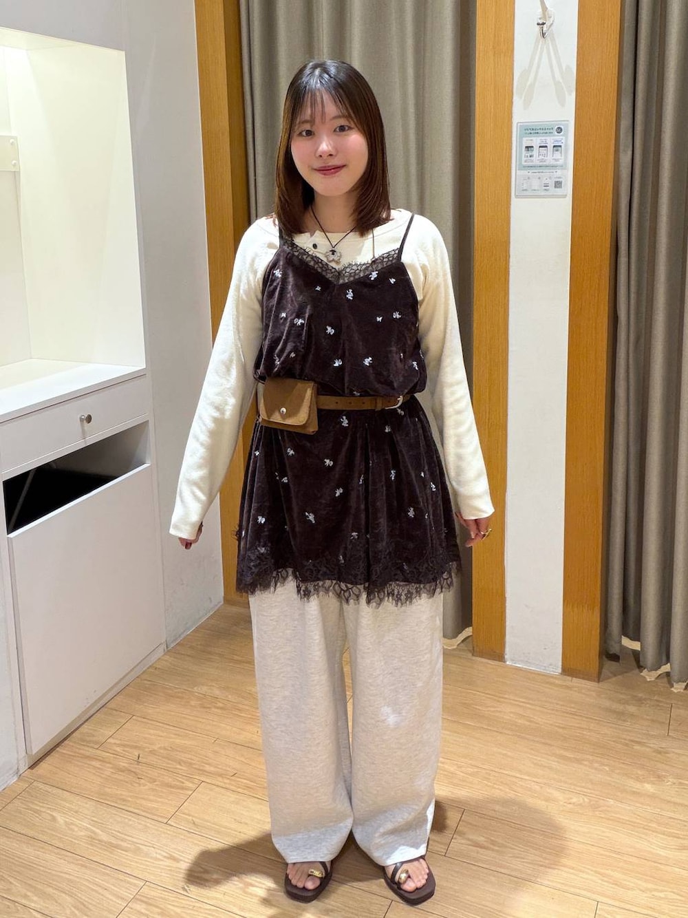 ホワイト系のニット/セーター、ブラウン系のワンピース、グレー系のスウェットパンツを着用したレディースの秋コーディネートの1枚目の写真