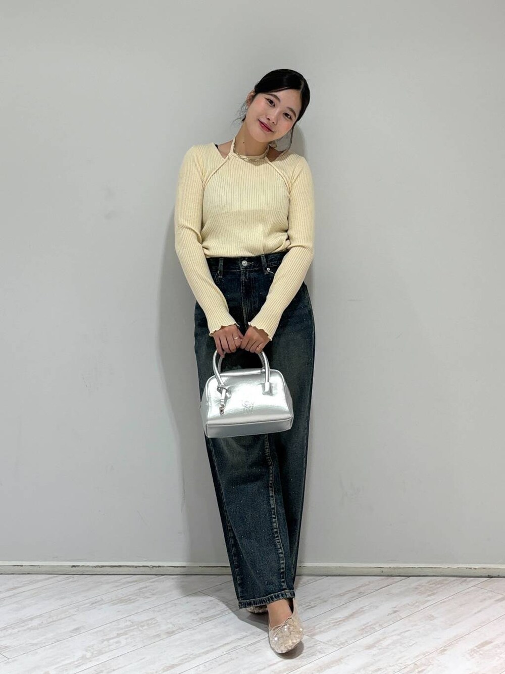 ブルー系のデニムパンツ、シルバー系のボストンバッグ、ホワイト系のバレエシューズを着用したレディースの秋コーディネートの1枚目の写真