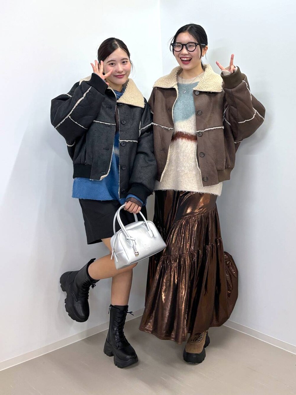 ブラック系のブルゾン、ブラウン系のブルゾン、ホワイト系のニット/セーターを着用したレディースの冬コーディネートの1枚目の写真