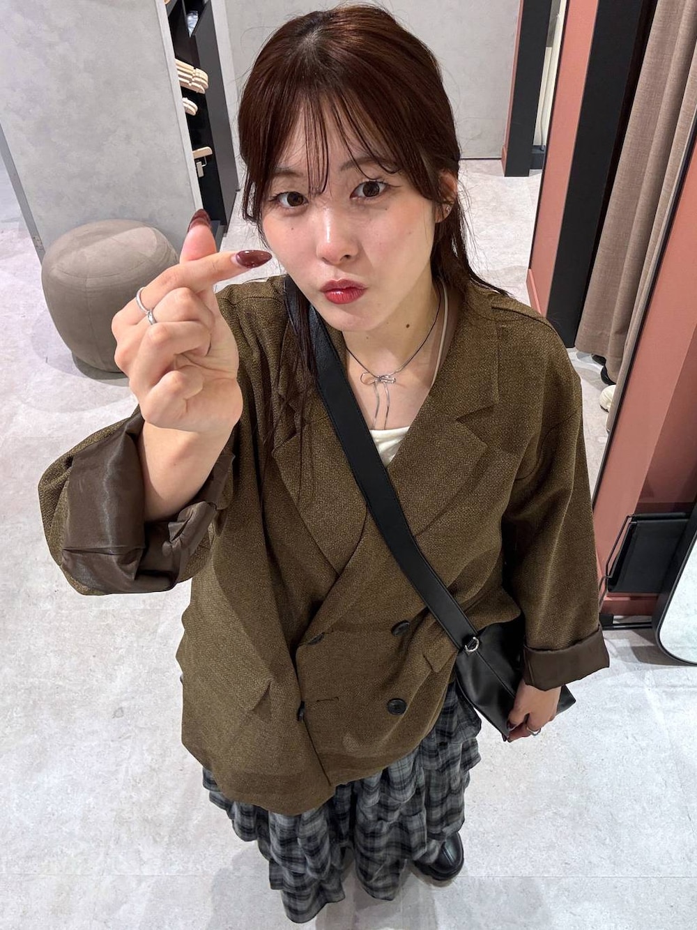 ブラック系のブーツ、ベージュ系のテーラードジャケット、ホワイト系のキャミソールを着用したレディースの秋コーディネートの1枚目の写真