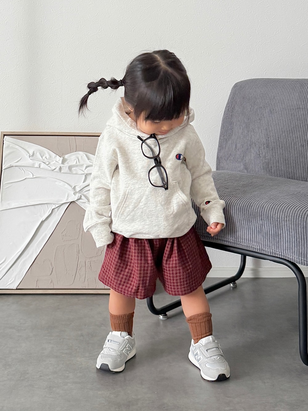 グレー系のスニーカー、グレー系のパーカー、レッド系のパンツを着用したキッズの秋コーディネートの1枚目の写真