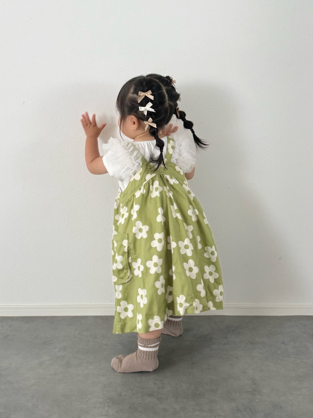 ホワイト系のTシャツ/カットソー、グリーン系のジャンパースカートを着用したキッズの夏コーディネートの1枚目の写真