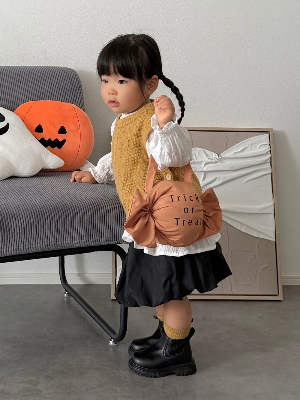 ブラック系のスカート、イエロー系のニット/セーター、オレンジ系の雑貨/ホビーを着用したキッズの秋コーディネートの1枚目の写真