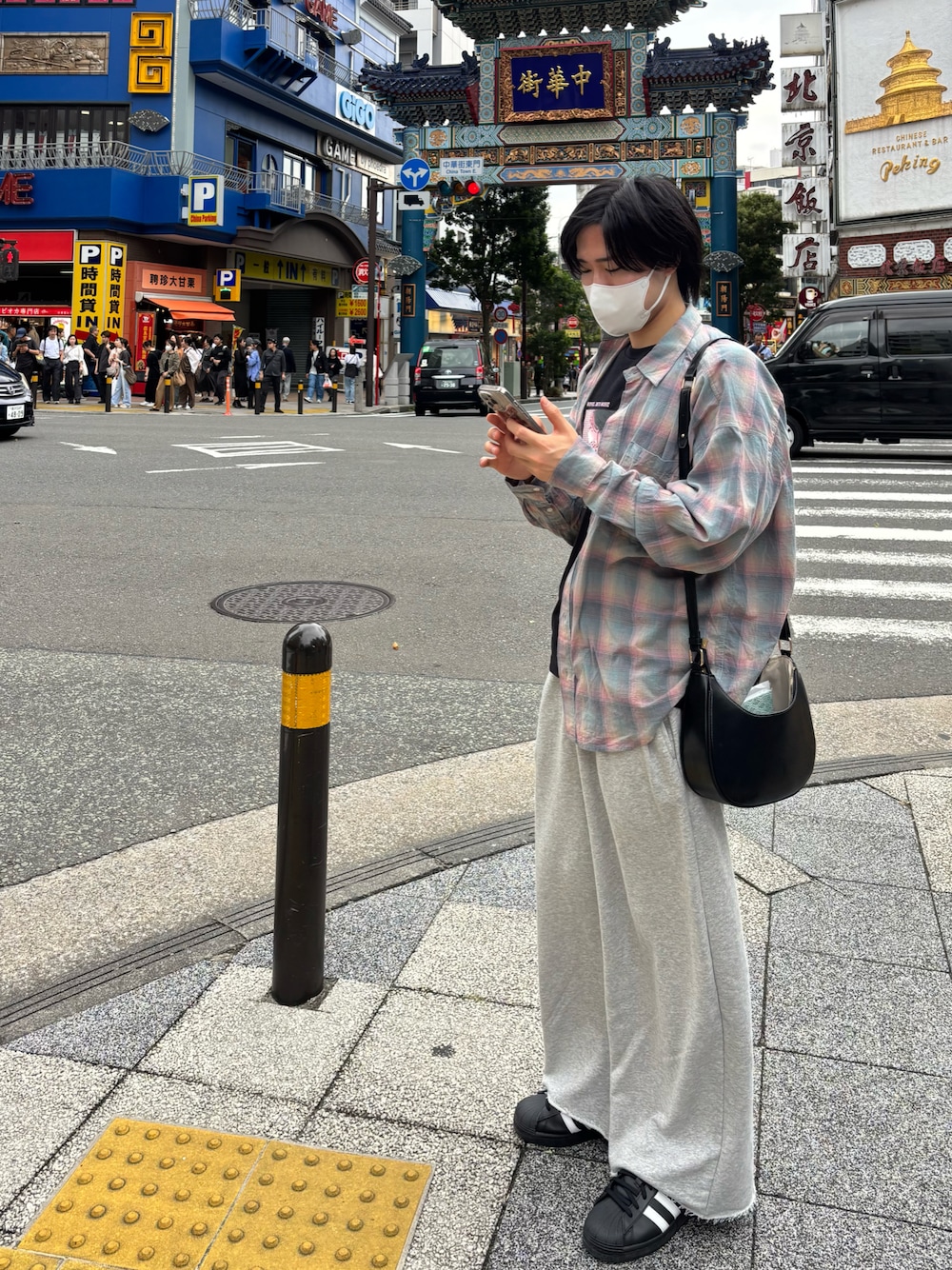 グレー系のスウェットパンツ、ブラック系のショルダーバッグ、ブラック系のスニーカーを着用したメンズの秋コーディネートの1枚目の写真