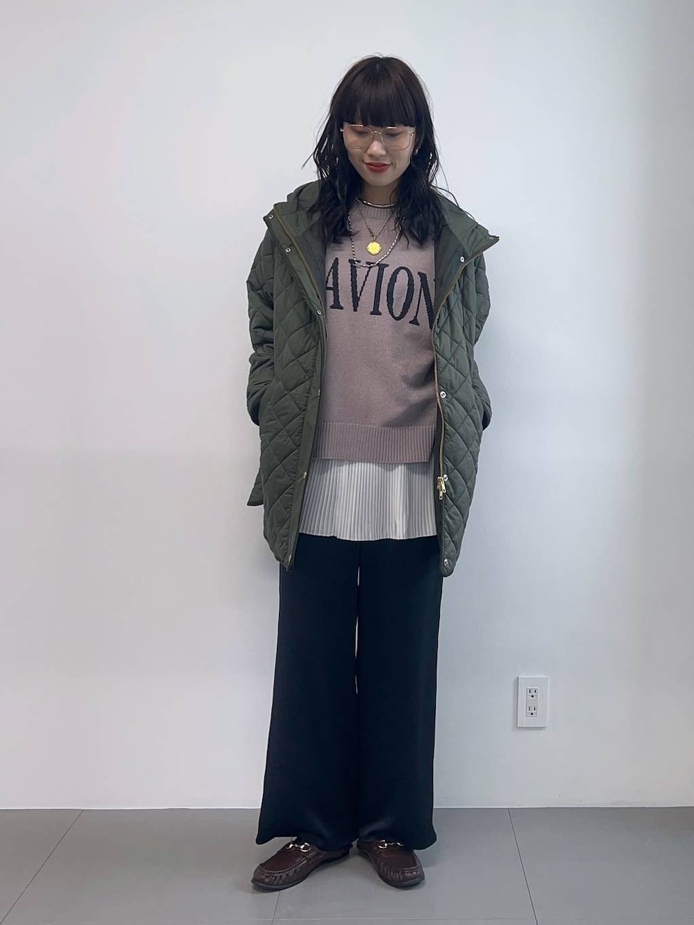 グリーン系のブルゾン、ブラウン系のローファー、グレー系のニット/セーターを着用したレディースの秋コーディネートの1枚目の写真