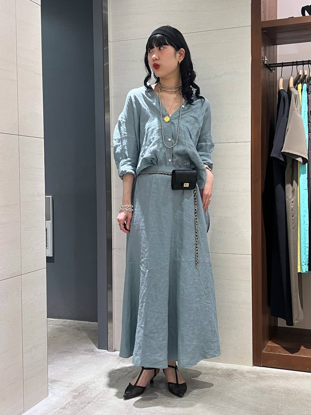 グリーン系のシャツ/ブラウス、グリーン系のスカート、ブラック系のパンプスを着用したレディースの春コーディネートの1枚目の写真