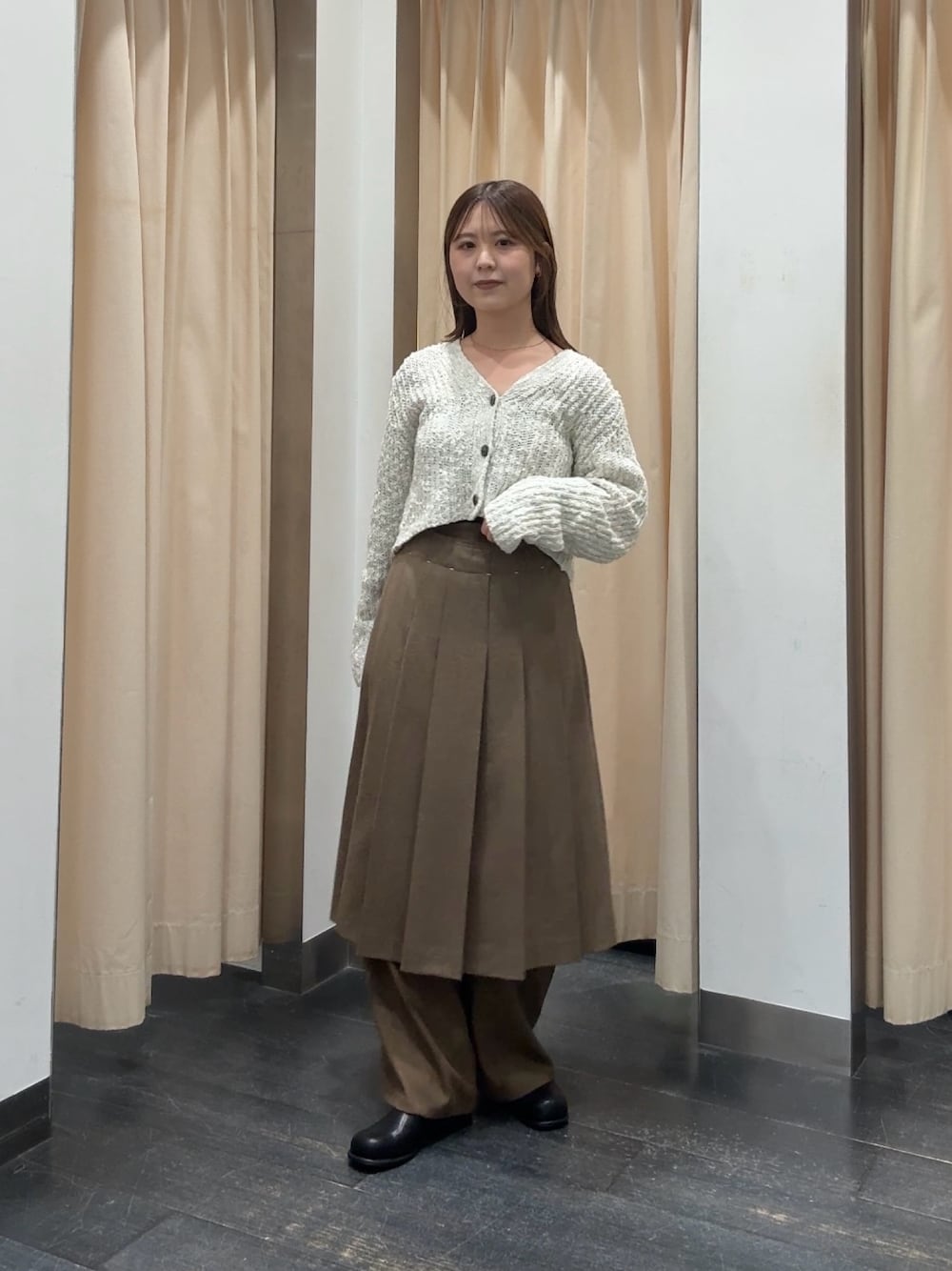 ホワイト系のニット/セーター、ブラウン系のスカート、ブラウン系のその他パンツを着用したレディースの秋コーディネートの1枚目の写真