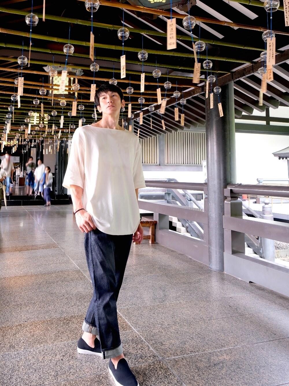ホワイト系のTシャツ/カットソー、ブラック系のスニーカー、ブルー系のデニムパンツを着用したメンズの夏コーディネートの1枚目の写真