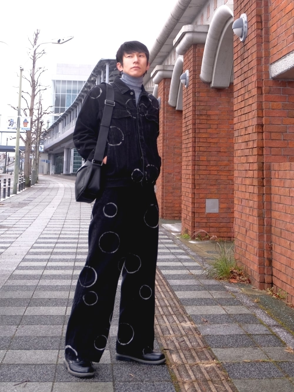 ブラック系のデニムジャケット、ブルー系のデニムパンツ、ブラック系のブーツを着用したメンズの冬コーディネートの1枚目の写真