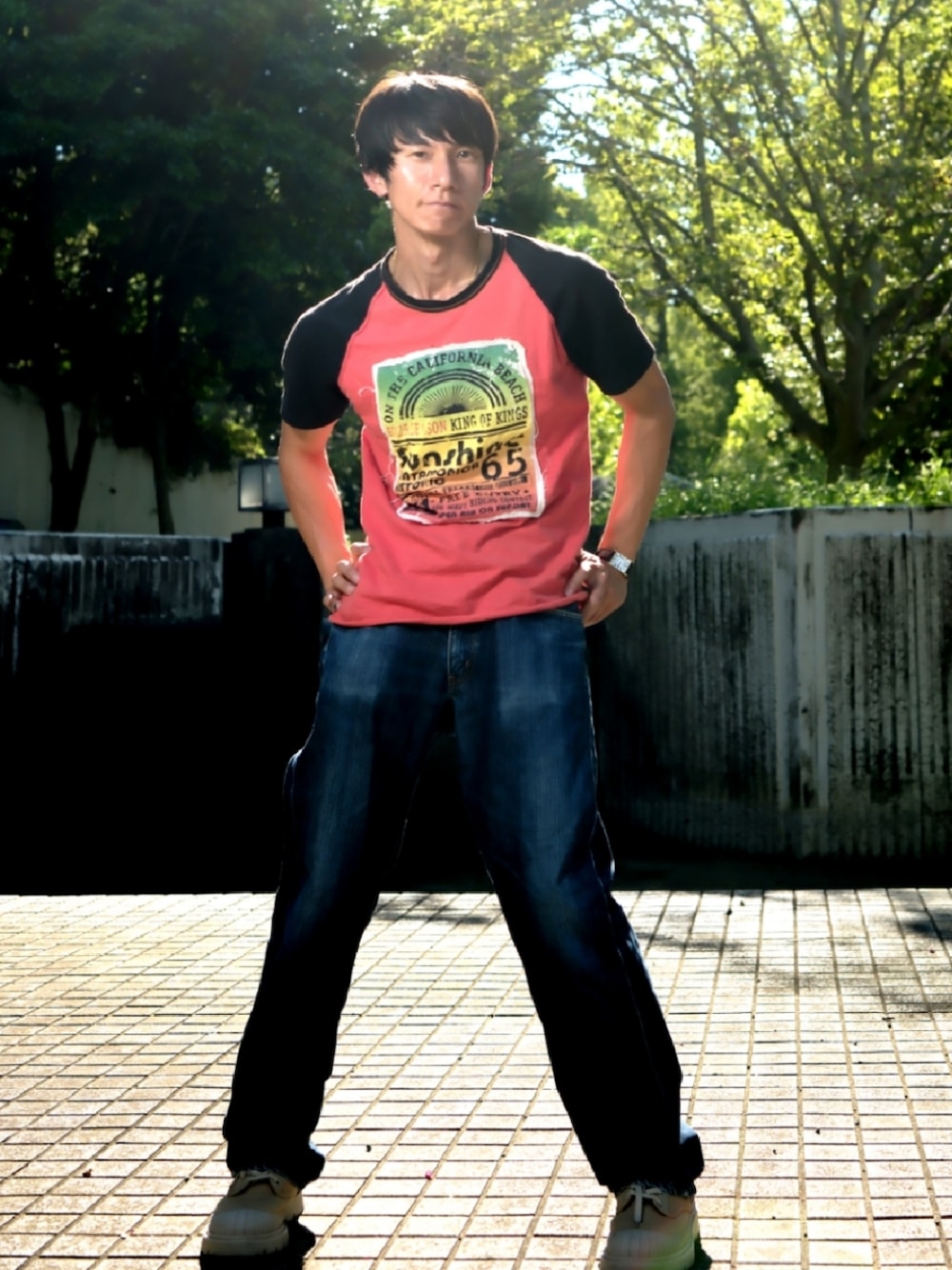 レッド系のTシャツ/カットソー、ベージュ系のブーツ、ゴールド系のアナログ腕時計を着用したメンズの夏コーディネートの1枚目の写真