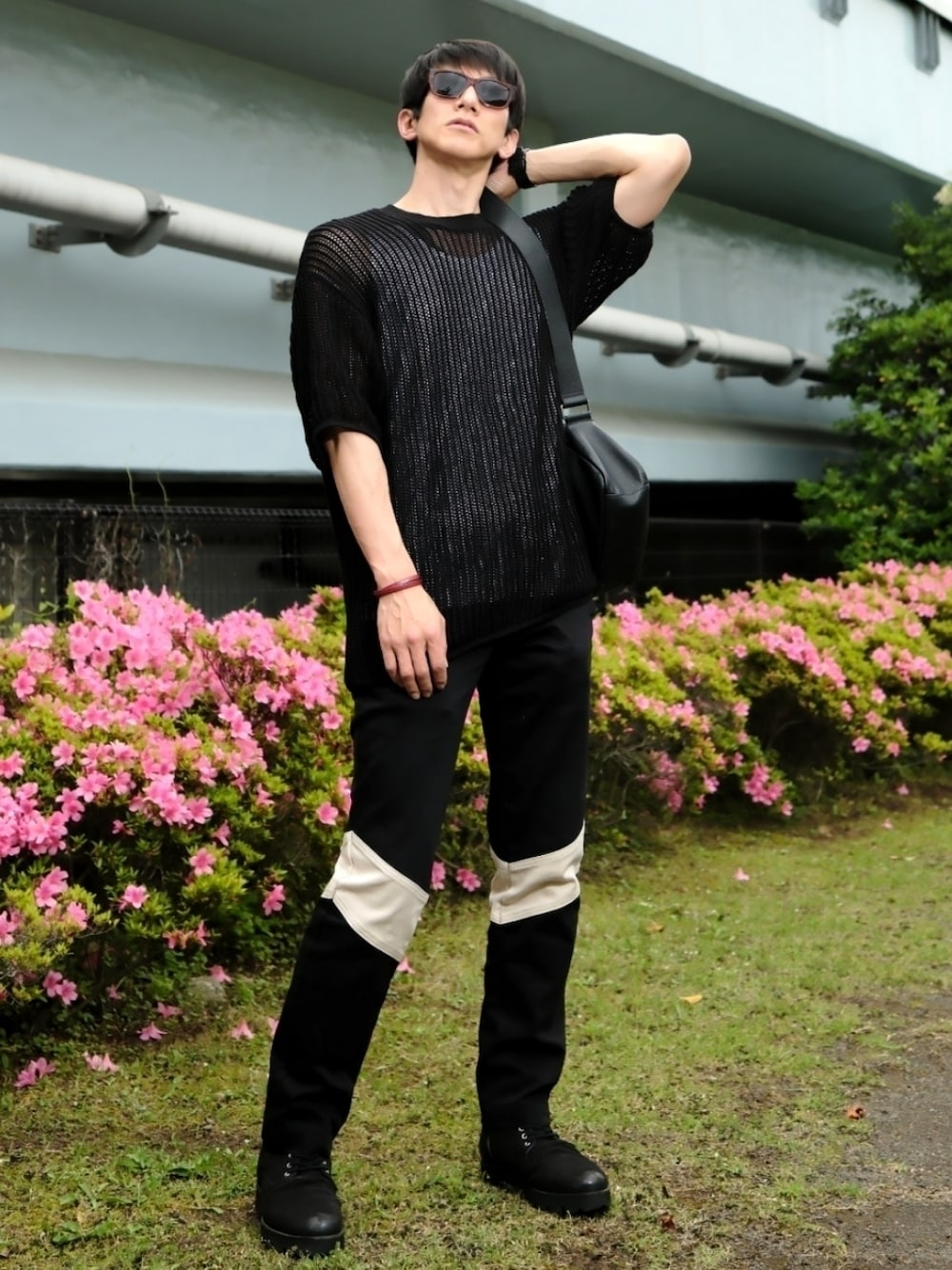 ブラック系のトップス、ホワイト系のタンクトップ、ブラック系のメッセンジャーバッグを着用したメンズの春コーディネートの1枚目の写真