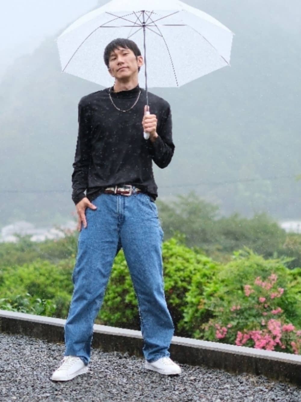 ブルー系のデニムパンツ、ブラック系のTシャツ/カットソー、ホワイト系のスニーカーを着用したメンズの秋コーディネートの1枚目の写真