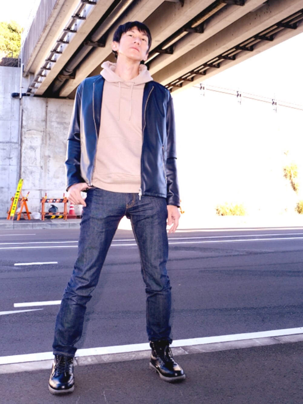 ベージュ系のパーカー、ブルー系のライダースジャケット、ブルー系のデニムパンツを着用したメンズの冬コーディネートの1枚目の写真