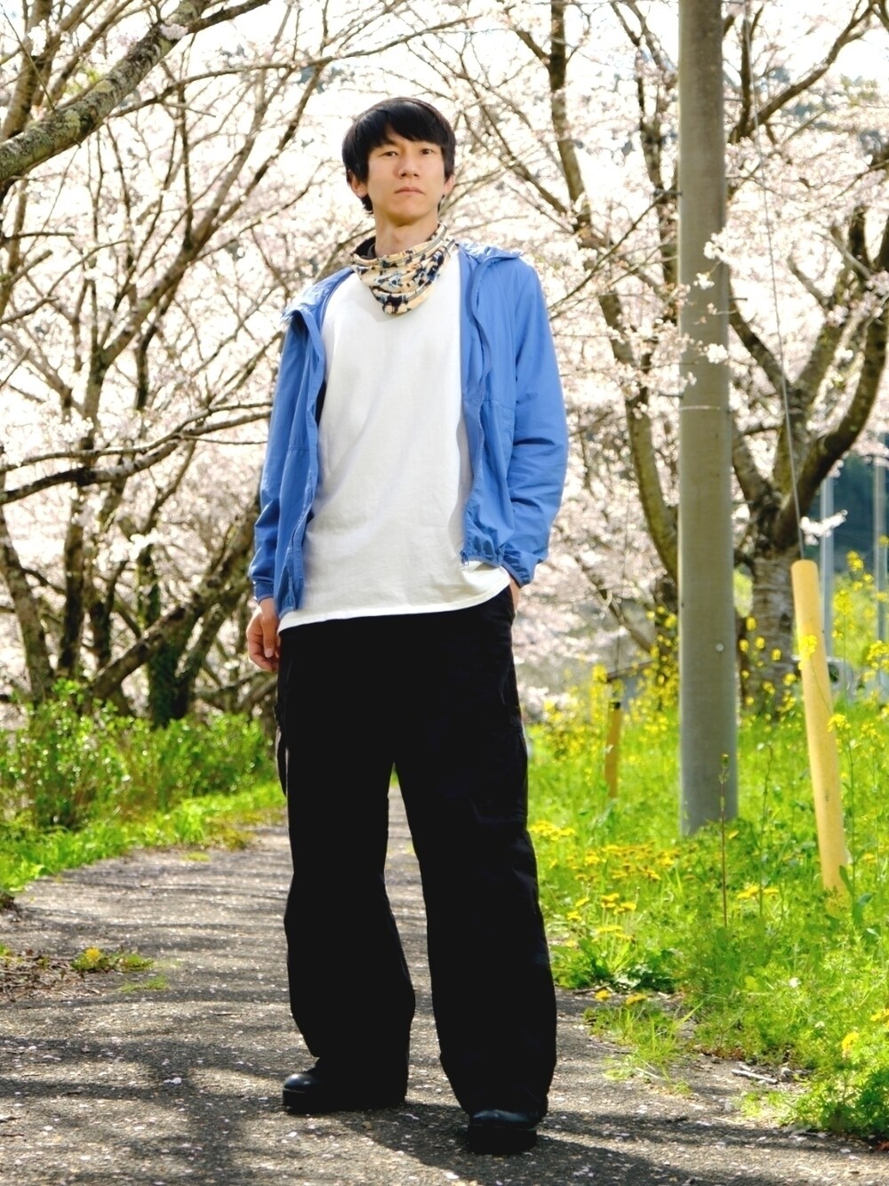 ブルー系のナイロンジャケット、ホワイト系のTシャツ/カットソー、ブラック系のカーゴパンツを着用したメンズの春コーディネートの1枚目の写真