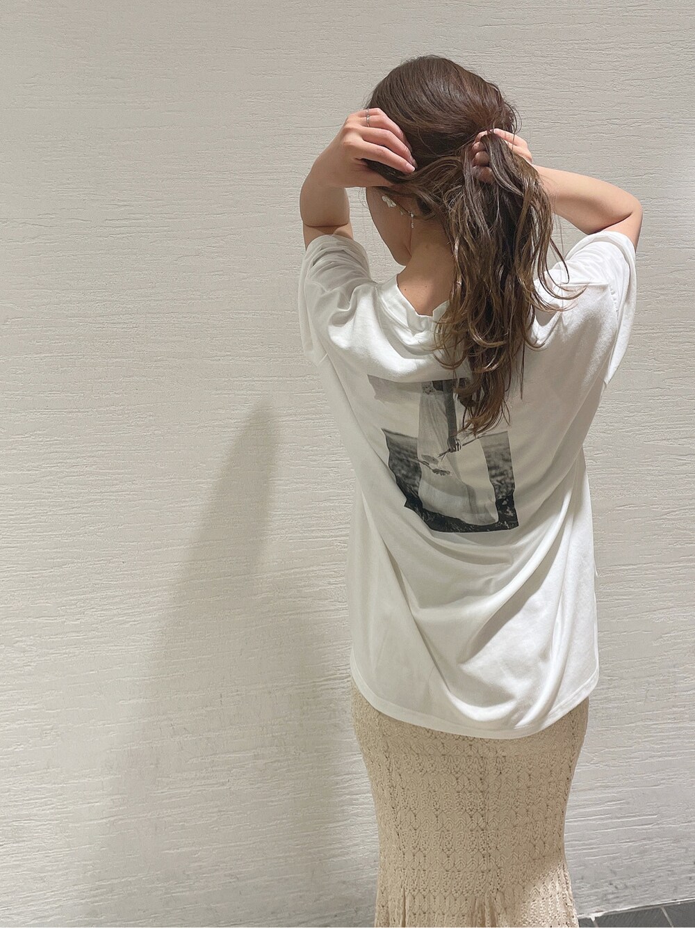 ブラウン系のサンダル、ホワイト系のTシャツ/カットソー、ホワイト系のスカートを着用したレディースの春コーディネートの1枚目の写真