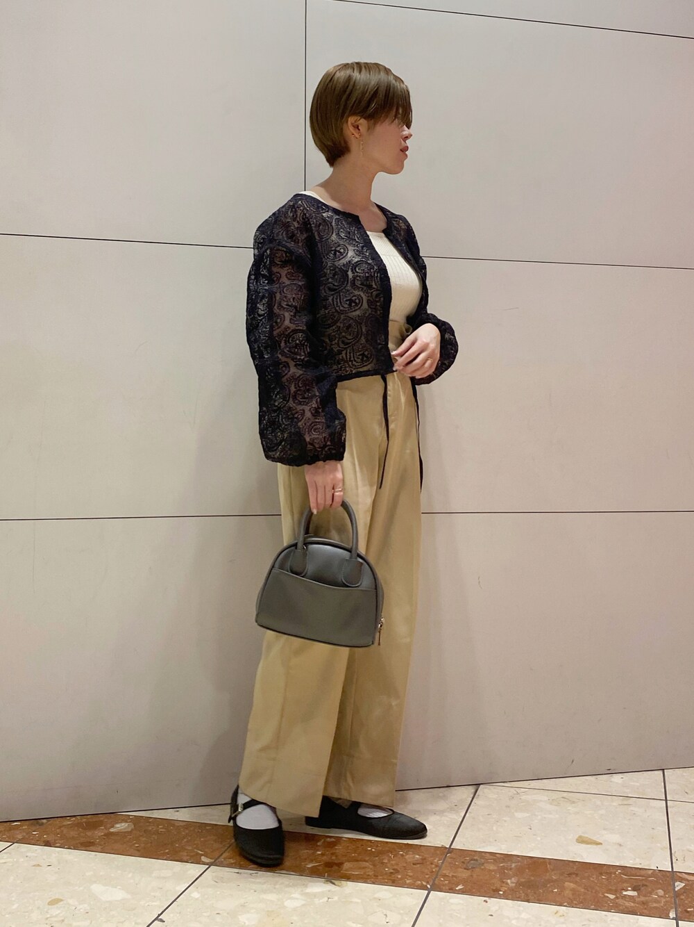 ブラック系のバレエシューズ、グレー系のバッグ、ベージュ系のチノパンツを着用したレディースの春コーディネートの1枚目の写真