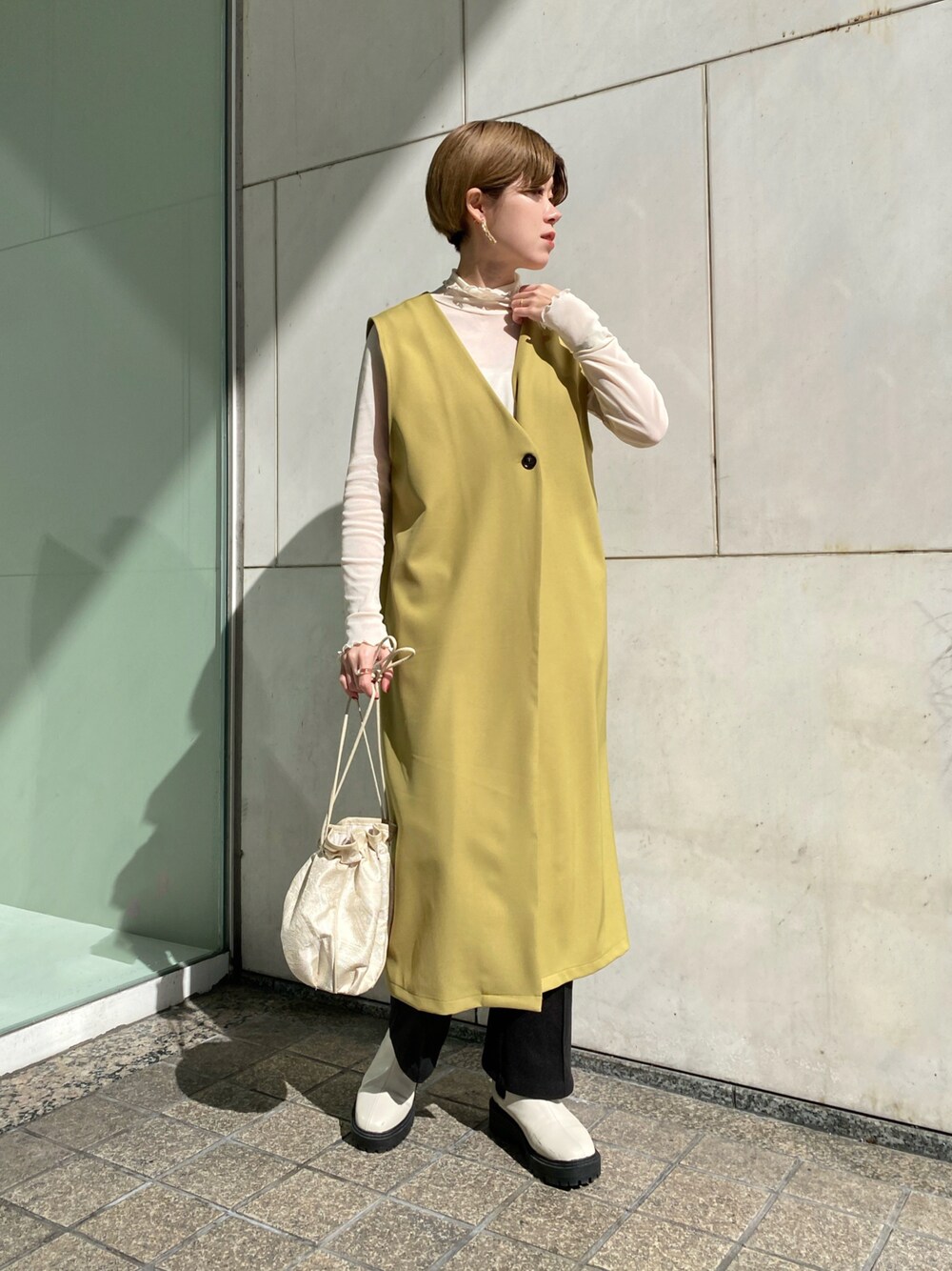 「シンプルコーデ、大人カジュアル、春、今日のコーデ、淡色コーデ、ジレ、ロングジレ、グリーン、春カラー、春コーデ、春服、白ブーツ、巾着バッグ、いいね、save、フォローお願いします🤑」｜「RAY CASSINのジャガード巾着2wayバッグ（バッグ、イエロー系）」を使った、nimoさん（レディース・155cm）の冬コーディネートの1枚目の写真