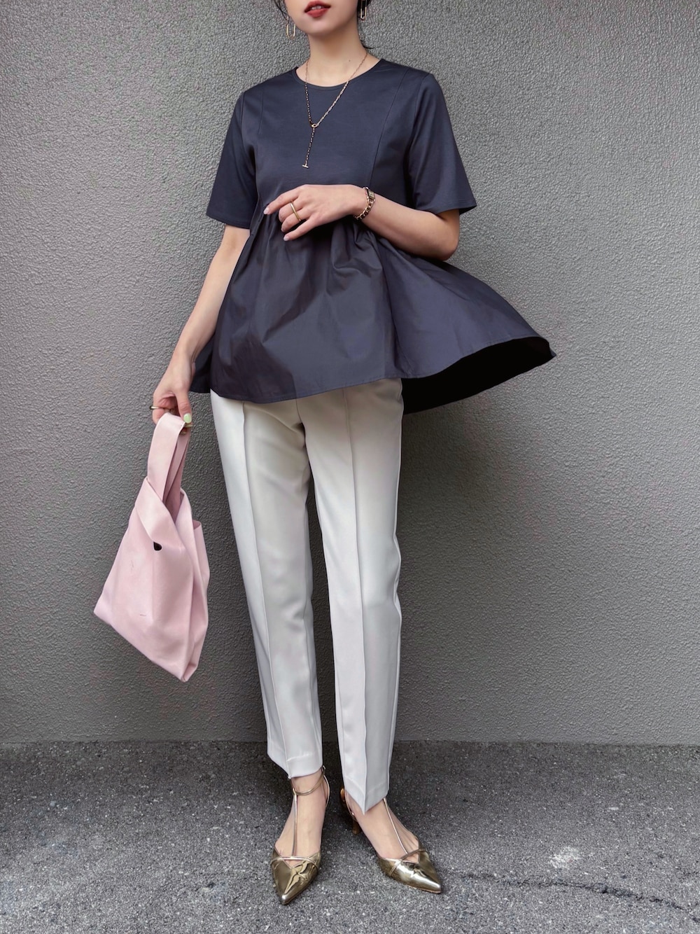 グレー系のTシャツ/カットソー、ベージュ系のその他パンツ、ゴールド系のパンプスを着用したレディースの春コーディネートの1枚目の写真