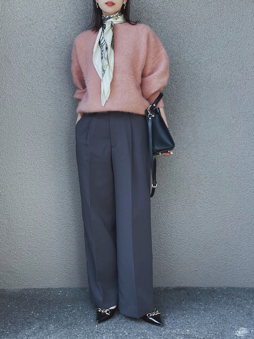 ピンク系のニット/セーター、グレー系のその他パンツ、ブラック系のパンプスを着用したレディースの秋コーディネートの1枚目の写真