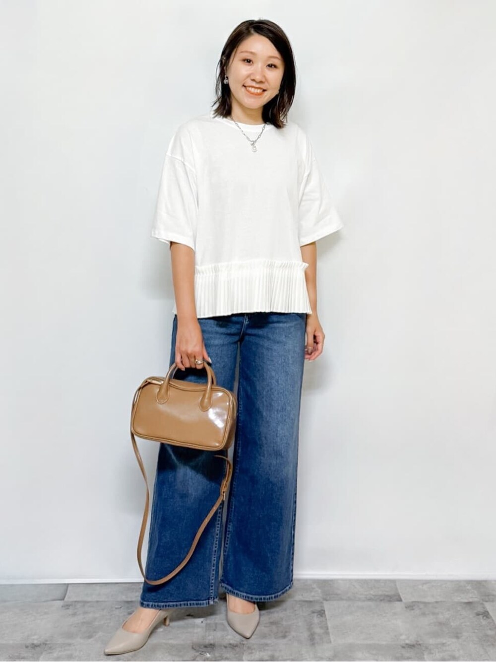 ホワイト系のTシャツ/カットソー、ブルー系のデニムパンツ、ベージュ系のショルダーバッグを着用したレディースの夏コーディネートの1枚目の写真
