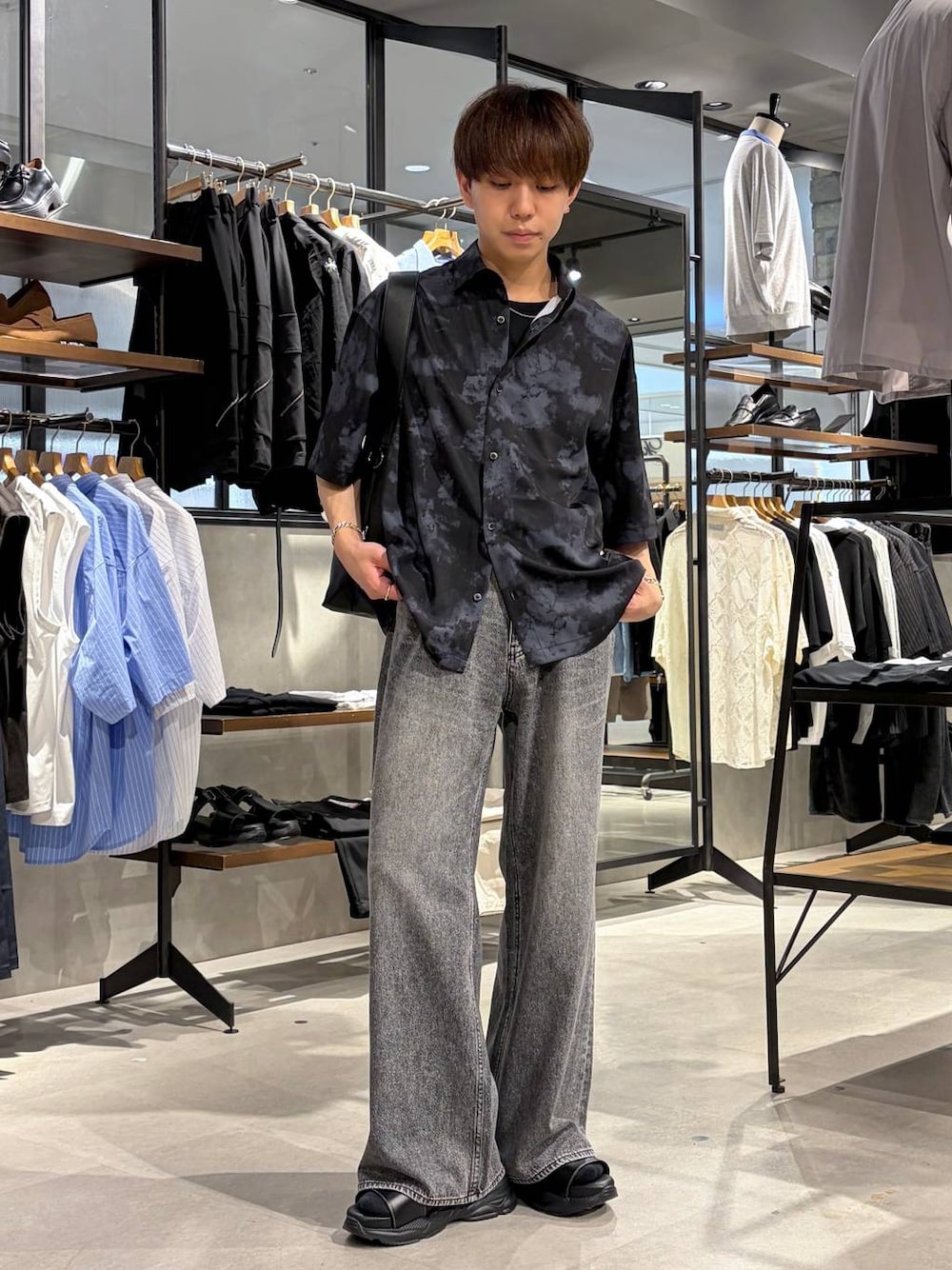 ブラック系のTシャツ/カットソー、グレー系のデニムパンツ、ブラック系のサンダルを着用したメンズの夏コーディネートの1枚目の写真