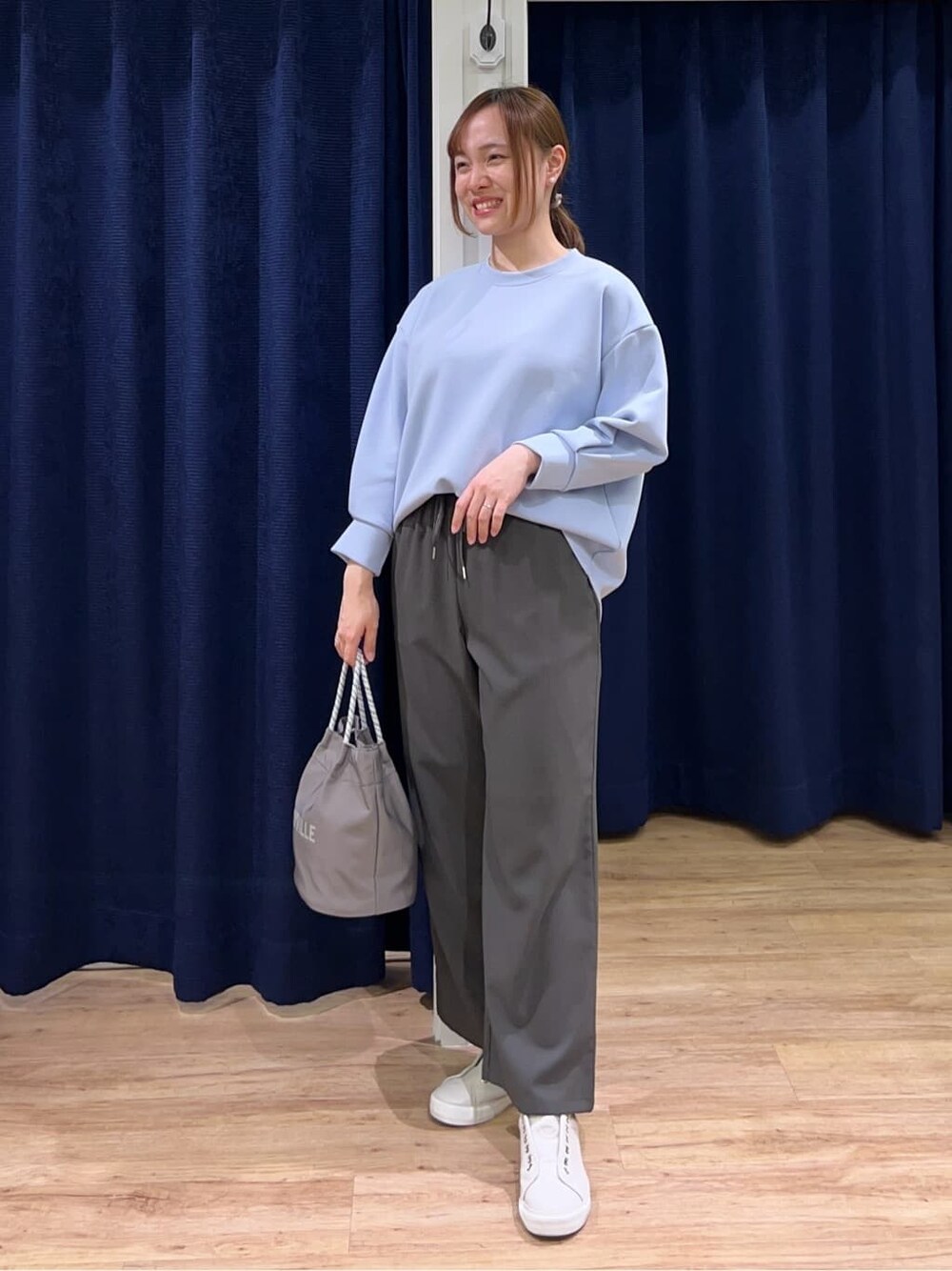 ブルー系のTシャツ/カットソー、グレー系のその他パンツ、グレー系のトートバッグを着用したレディースの春コーディネートの1枚目の写真