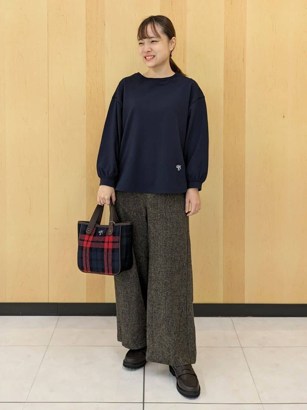 ブルー系のTシャツ/カットソー、ブラウン系のその他パンツ、レッド系のトートバッグを着用したレディースの秋コーディネートの1枚目の写真
