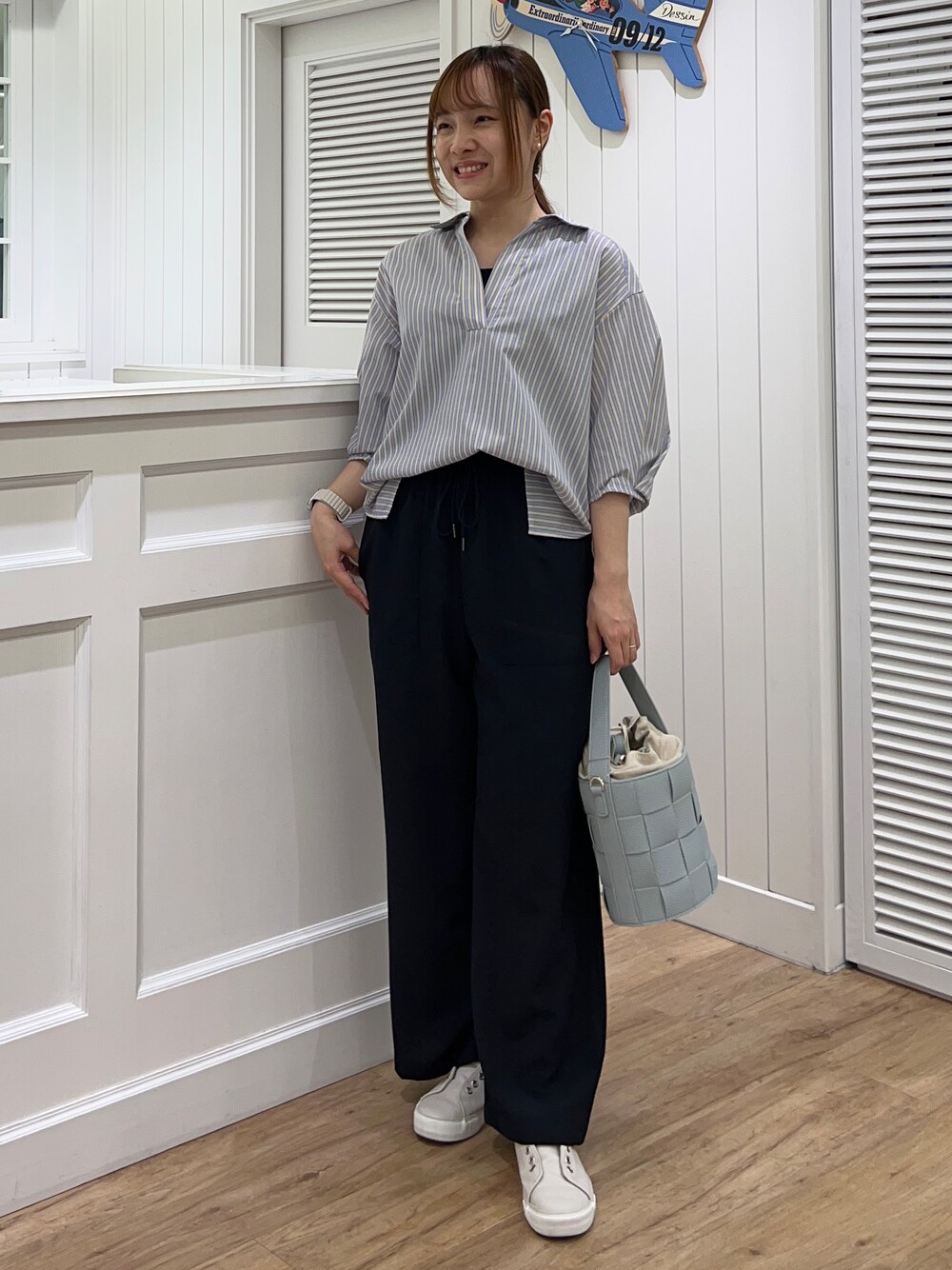 イエロー系のシャツ/ブラウス、ブルー系のその他パンツ、ブルー系のショルダーバッグを着用したレディースの春コーディネートの1枚目の写真