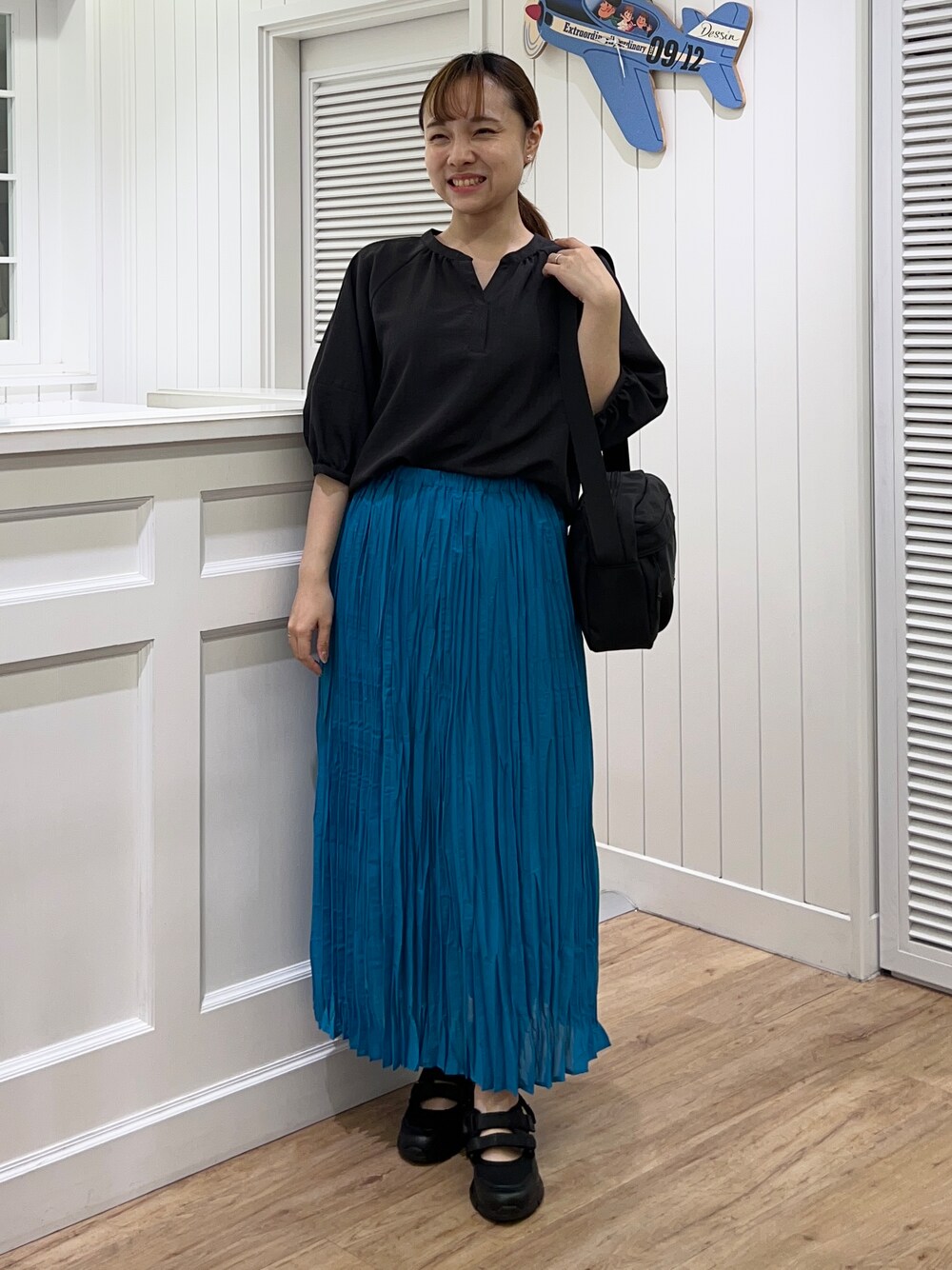 グレー系のシャツ/ブラウス、ブルー系のスカート、ブラック系のショルダーバッグを着用したレディースの春コーディネートの1枚目の写真
