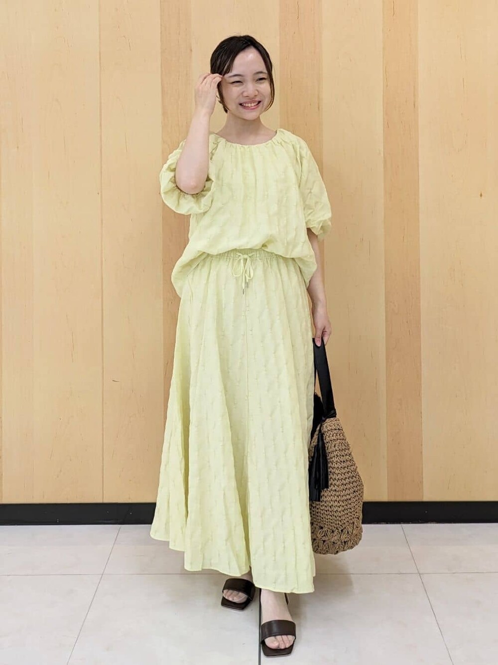 イエロー系のシャツ/ブラウス、イエロー系のスカート、ブラウン系のショルダーバッグを着用したレディースの夏コーディネートの1枚目の写真